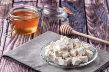 Sliced feta cheese with seasonings on a wooden table background
