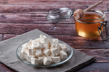 Sliced feta cheese with seasonings on a wooden table background