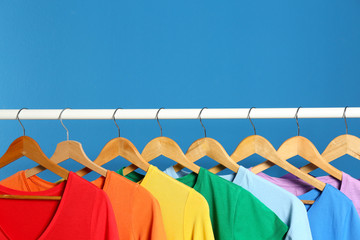 Bright clothes on blue background, space for text. Rainbow colors