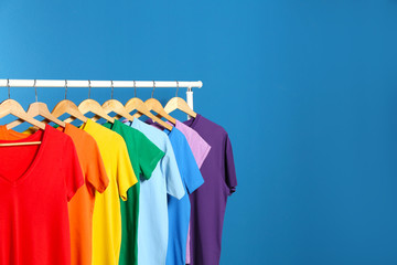 Bright clothes on blue background, space for text. Rainbow colors