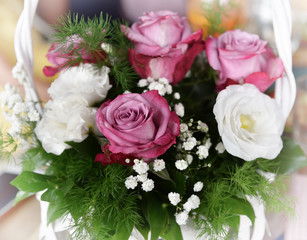 Bouquet of pink and white roses in the white basket 
