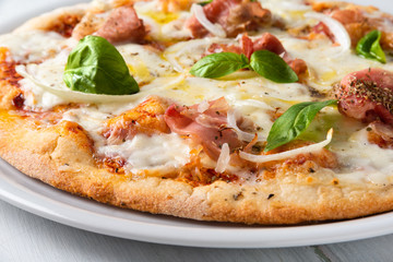 Pizza con prosciutto cotto, scaglie di grana, cipolla, mozzarella, pomodoro, origano e basilico fresco