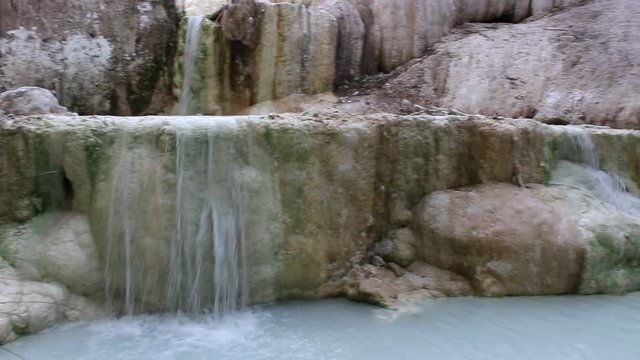 Cascade in a natural hot springs at San Filippo, Siena, Tuscany, Italy. This waterfall contains calcium carbonate deposits that form a white concretion called a white whale. 