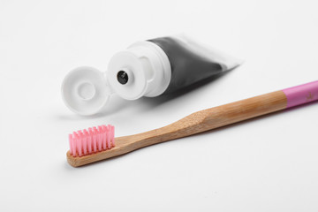 Bamboo toothbrush and charcoal paste isolated on white