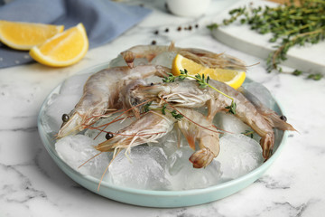 Raw shrimps with ice on marble table