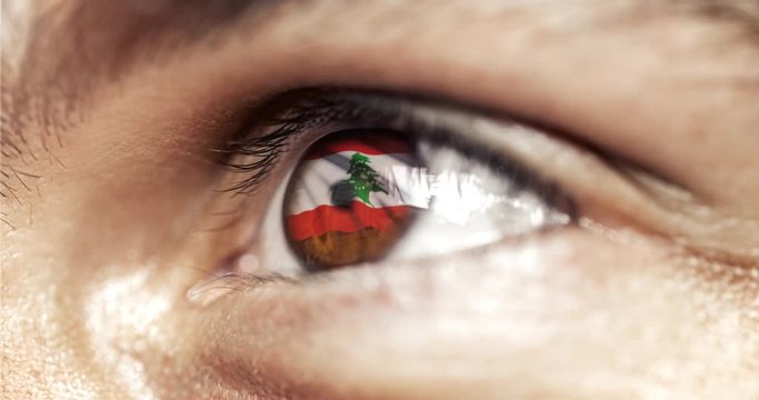 Man with brown eyes in close up, the flag of lebanon in iris,  with wind motion. video concept