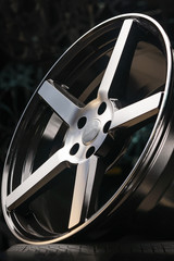 cast aluminum disc alloy wheel modern, close-up on black background, spokes and rim