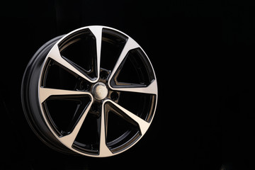 cast aluminum disc alloy wheel modern, close-up on black background, spokes and rim copy space