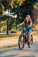 Fototapeta na wymiar Girl Riding Her Bike To School
