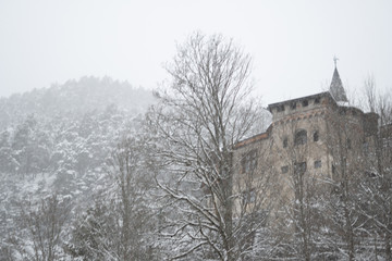 Schneelandschaft mit Burg im Hintergrund und See und Wald im Vordergrund am Fernsteinsee in Österreich Tirol 