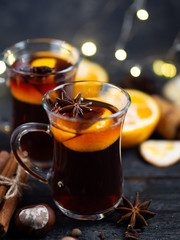 Traditional winter and Christmas hot drink mulled wine on a wooden table . With cinnamon, anise,...