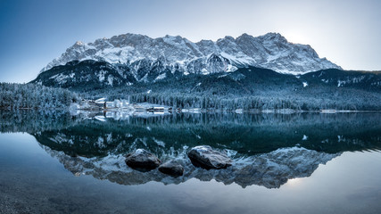Panorama view Zugspitze reflection in eibsee in winter at sunrise snow. very cold, frost, ice...