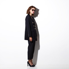 Fototapeta na wymiar High fashion portrait of young elegant woman. Sunglasses, black jacket, pants.