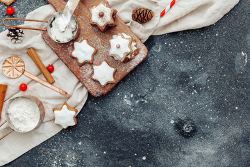Christmas background, star-shaped gingerbread cookies over curing board. Top view, flat lay