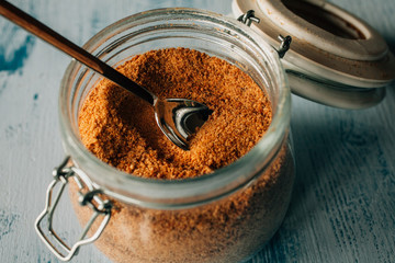 Panela sugar background. Close up view of raw cane sugar in a jar. 
