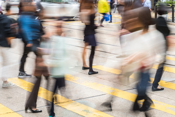 blurry people crossing street on pedestrian crossing 