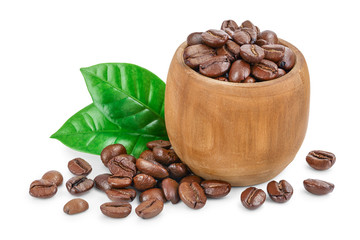 Heap of roasted coffee beans in wooden bowl with leaves isolated on white background.