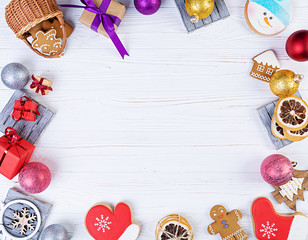 Christmas background. Christmas gift, toys, gingerbread cookies, spices and decorations on wooden background. Top view