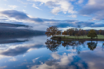 Breathtaking vibrant aerial drone landscape images over Coniston Water at sunrise on beautiful Autumn Fall morning