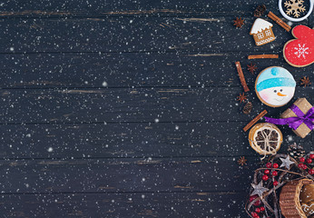 Christmas background. Christmas gift, toys, gingerbread cookies, spices and decorations on wooden background. Top view