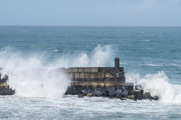 powerful waves breaking at breakwater during a storm