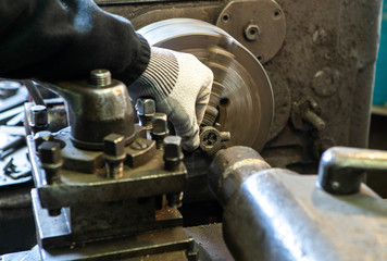Metalwork equpment. Close-up of lathe and worker`s hand. Thread cutting on a stud.
