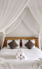 Clean white pillows and bed sheets in beautiful bedroom. Close-up. Bali island Indonesia.