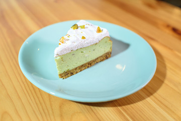 Bright and tasty pistachio cake on a large light wooden table