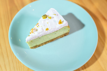 Bright and tasty pistachio cake on a large light wooden table