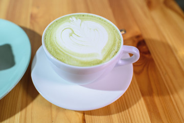 Matcha latte close-up on a large bright wooden table