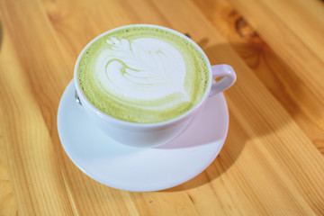 Matcha latte close-up on a large bright wooden table
