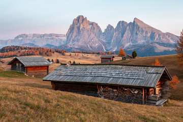 Fototapeta na wymiar Mountain meadow and house Alpe di Siusi or Seiser Alm in the background Langkofel mountain range at sunset with Province of Bolzano, South Tyrol in Dolomites