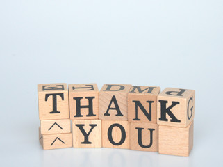 The wooden blocks are printed THANK YOU and isolated on white background.