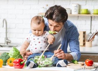 Funny dad preparing lunch with baby son at kitchen