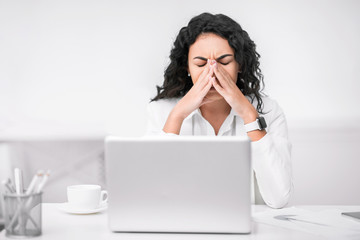 Fatigued executive woman massaging nose and eyes