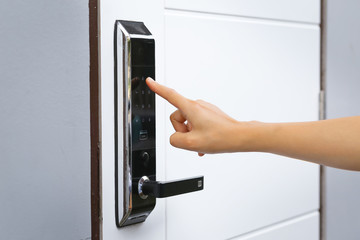 Close-up hand pressing keywords to lock and unlock door - Door access control keypad with keycard...