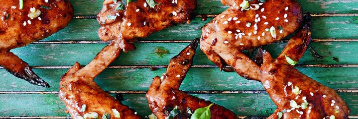 Hot buffalo chicken wings with soy sauce dressing of green onions and lime. Appetizing bar snack. American traditional dish. B-B-Q