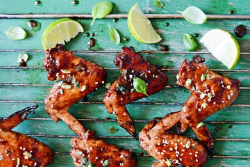 Hot buffalo chicken wings with soy sauce dressing of green onions and lime. Appetizing bar snack. American traditional dish. B-B-Q
