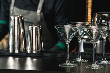 Glasses for a margarita, martini, grog and liqueur on a bar at restaurant, against the bar bar wall...