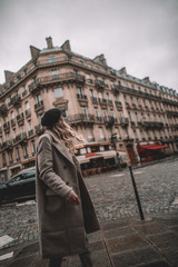 Fototapeta premium Woman with parisian style in front of old Paris building