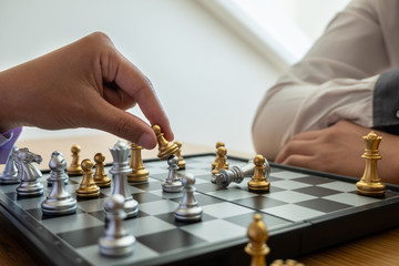 hand of businessman moving chess in competition, shows leadership, followers and business success strategies