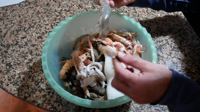 Fresh seafood ready to be cooked. A tray of prawns, sea cicadas, cuttlefish, clams and mussels ready to prepare a fish soup