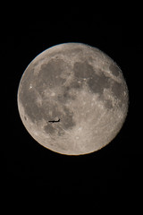 Passenger plane flying in front of full moon at night, Germany