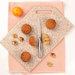 Fresh muffins on a kitchen cutting board made of artificial stone