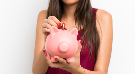 Fototapeta na wymiar Young woman over isolated white background holding a big piggybank