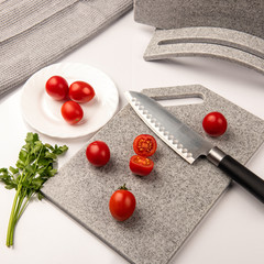 Fresh tomatoes on a cutting kitchen board made of artificial stone