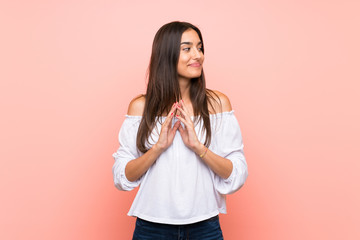 Young woman over isolated pink background scheming something