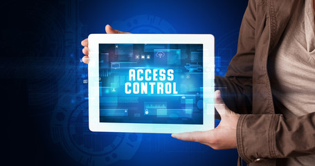 Young business person working on tablet and shows the digital sign: ACCESS CONTROL