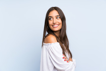 Young woman over isolated blue background laughing