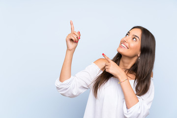 Young woman over isolated blue background pointing with the index finger a great idea